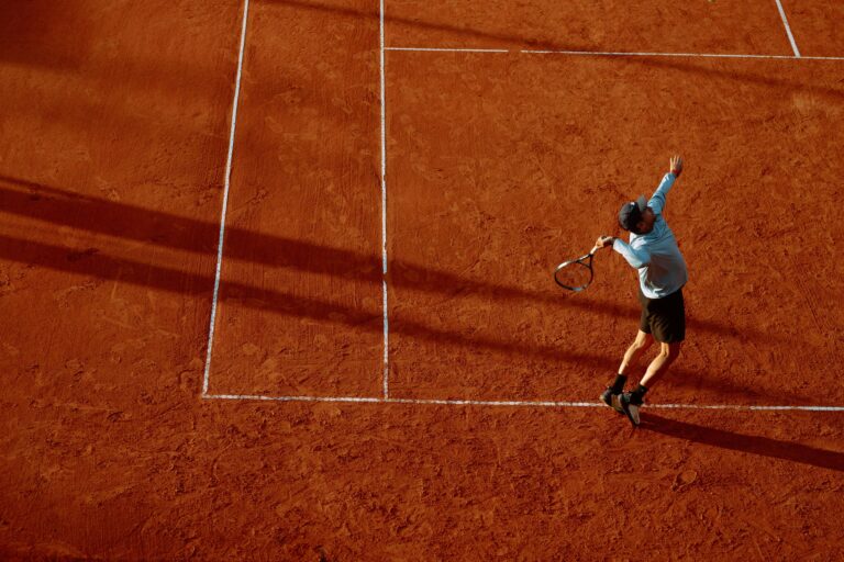 Jucator de tenis in actiune pe teren cu zgura
